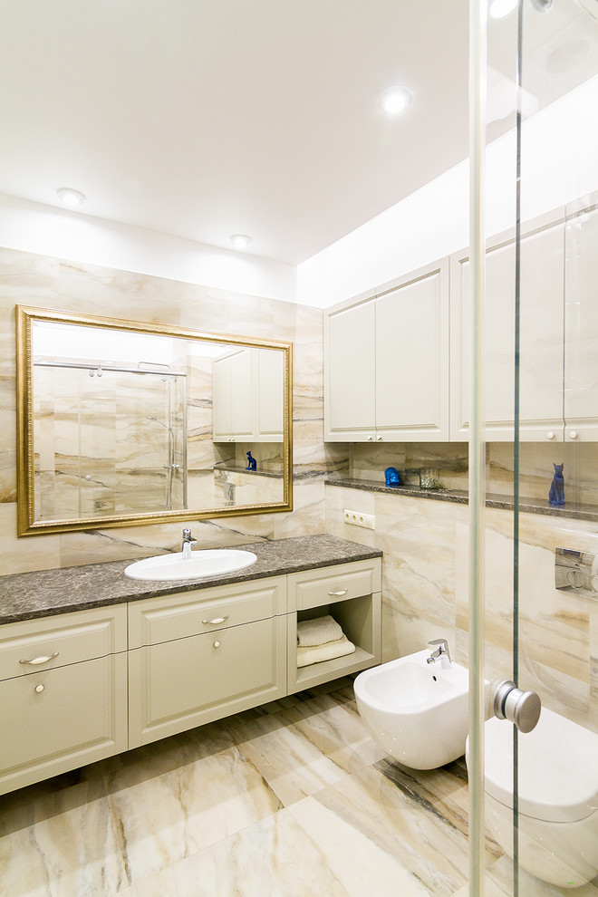 Imagen de cuarto de baño clásico renovado con armarios con paneles con relieve, bidé, baldosas y/o azulejos beige, lavabo encastrado, suelo beige y encimeras grises