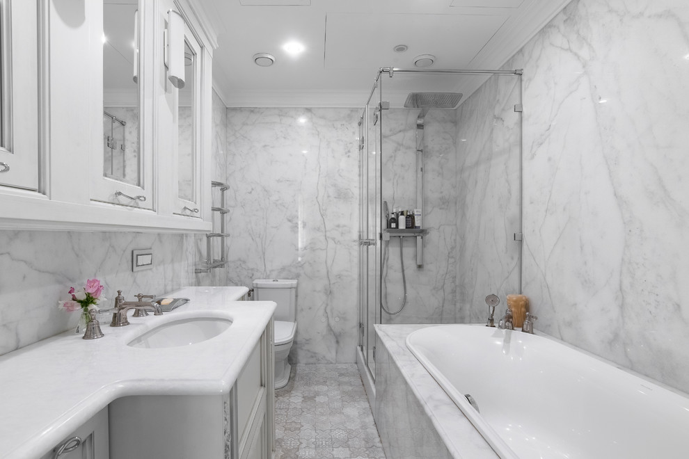 На фото: главная ванная комната среднего размера в стиле неоклассика (современная классика) с фасадами с выступающей филенкой, белыми фасадами, накладной ванной, душем в нише, белой плиткой, серой плиткой, мраморной плиткой, мраморным полом, врезной раковиной, мраморной столешницей, бежевым полом, душем с раздвижными дверями, белой столешницей и раздельным унитазом