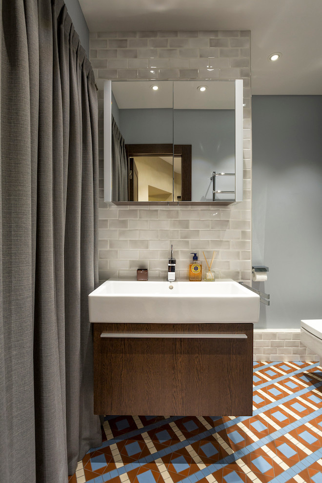 Идея дизайна: ванная комната в стиле лофт с плоскими фасадами, фасадами цвета дерева среднего тона, серой плиткой, серыми стенами, полом из керамической плитки и консольной раковиной
