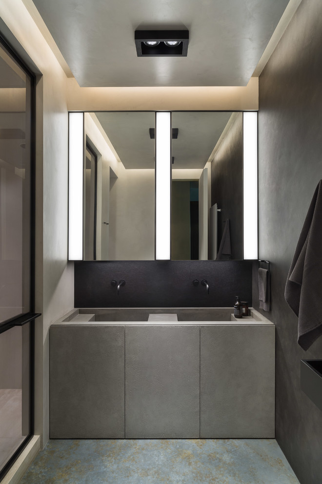 Exempel på ett mellanstort modernt grå grått en-suite badrum, med släta luckor, grå skåp, våtrum, en vägghängd toalettstol, marmorkakel, svarta väggar, betonggolv, ett integrerad handfat, bänkskiva i betong, blått golv och dusch med gångjärnsdörr