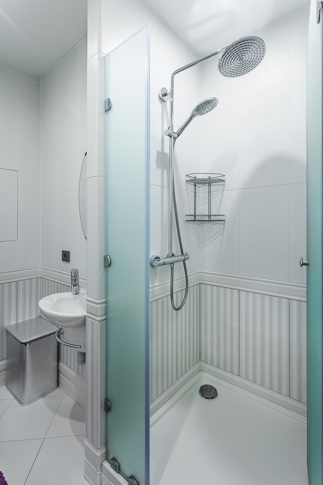 Photo of a contemporary shower room bathroom in Moscow with an alcove shower, white walls, a wall-mounted sink, white tiles, a hinged door, a wall mounted toilet, ceramic tiles, ceramic flooring and white floors.