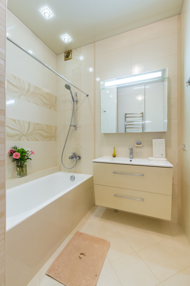 Inspiration pour une salle de bain design avec une baignoire posée, un combiné douche/baignoire et un mur beige.