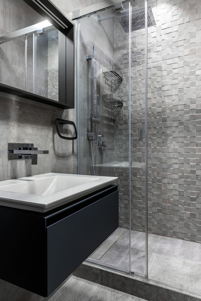 Idee per una stanza da bagno con doccia contemporanea con ante lisce, ante nere, piastrelle grigie, lavabo integrato, pavimento grigio, porta doccia scorrevole, un lavabo e mobile bagno sospeso