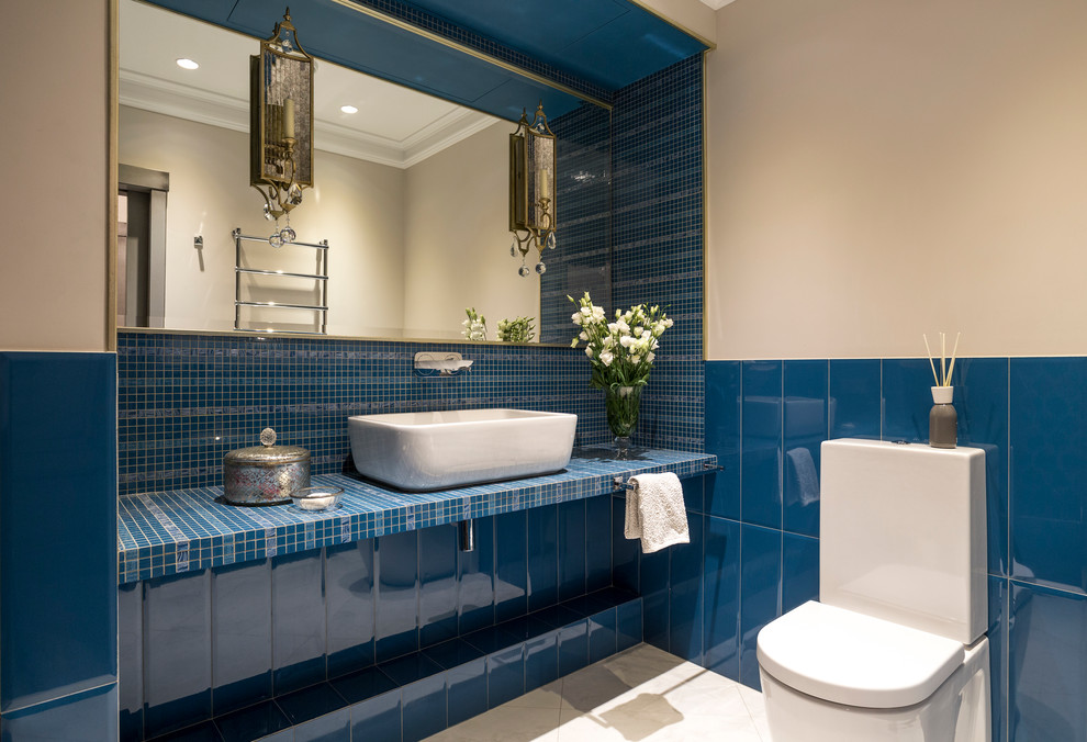 На фото: ванная комната в стиле фьюжн с раздельным унитазом, синей плиткой, бежевыми стенами и настольной раковиной