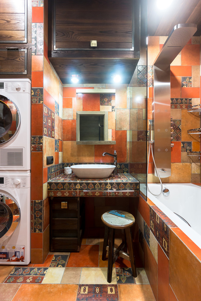 This is an example of a small eclectic ensuite bathroom in Moscow with brown cabinets, a shower/bath combination, multi-coloured tiles, orange tiles, porcelain tiles, porcelain flooring, tiled worktops, multi-coloured floors, a shower curtain, an alcove bath, a vessel sink and multi-coloured worktops.