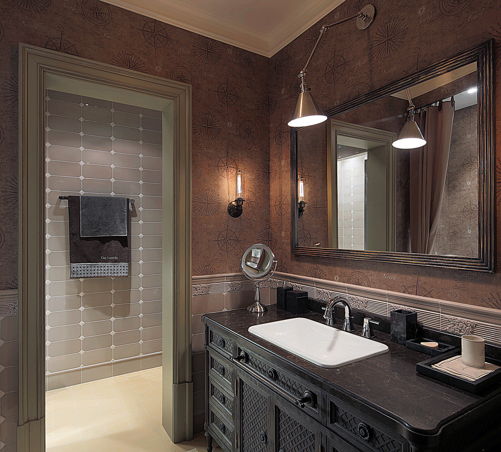 Exemple d'une salle de bain principale chic avec un carrelage beige, un mur marron, des portes de placard noires et un lavabo posé.