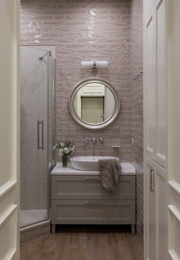 This is an example of a traditional shower room bathroom in Moscow with recessed-panel cabinets, grey cabinets, a corner shower, a vessel sink, brown floors, a hinged door, white worktops, grey tiles, metro tiles and dark hardwood flooring.