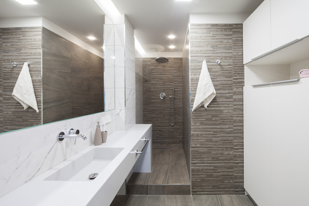 Foto de cuarto de baño contemporáneo con ducha empotrada, baldosas y/o azulejos blancos, baldosas y/o azulejos marrones, aseo y ducha, lavabo integrado, suelo marrón y ducha abierta