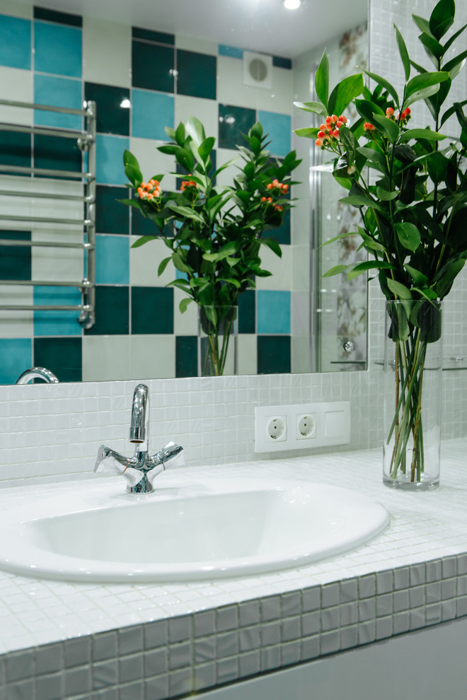 На фото: главная ванная комната среднего размера в современном стиле с плоскими фасадами, белыми фасадами, накладной ванной, зеленой плиткой, керамической плиткой, белыми стенами, полом из керамогранита, врезной раковиной, столешницей из плитки, синим полом и белой столешницей с