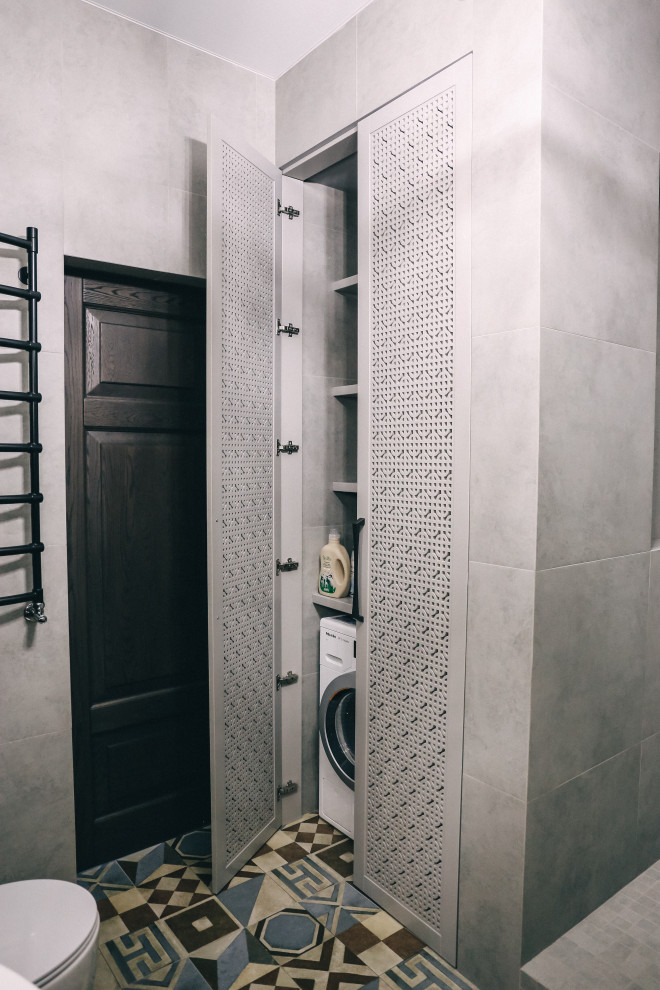 Идея дизайна: главная ванная комната среднего размера со стиральной машиной в стиле лофт с ванной в нише, открытым душем, инсталляцией, серой плиткой, керамогранитной плиткой, серыми стенами, полом из керамогранита, накладной раковиной, столешницей из дерева, разноцветным полом, открытым душем, желтой столешницей, тумбой под одну раковину, подвесной тумбой, плоскими фасадами и серыми фасадами