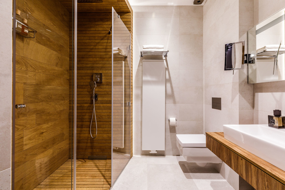 Пример оригинального дизайна: ванная комната в белых тонах с отделкой деревом в современном стиле с плоскими фасадами, темными деревянными фасадами, инсталляцией, серой плиткой, душевой кабиной, настольной раковиной, серым полом и коричневой столешницей