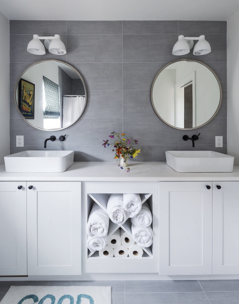 Cette photo montre une salle de bain chic avec un placard à porte shaker, des portes de placard blanches, un carrelage gris, une vasque, un sol gris, un plan de toilette blanc, meuble double vasque et meuble-lavabo encastré.