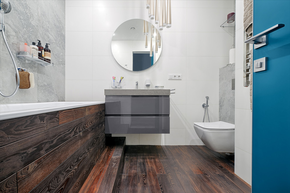 Inspiration for a contemporary bathroom in Moscow with flat-panel cabinets, grey cabinets, a wall mounted toilet, white tiles, dark hardwood flooring, brown floors, grey worktops and a floating vanity unit.