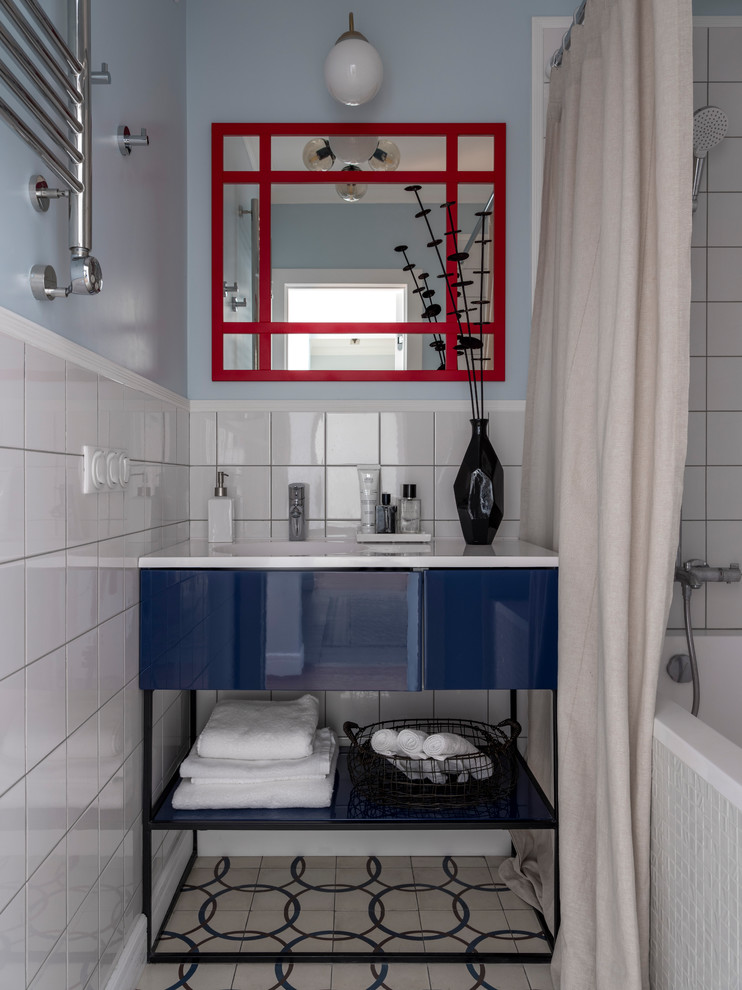 Esempio di una piccola stanza da bagno padronale design con ante lisce, ante blu, vasca ad alcova, vasca/doccia, piastrelle bianche, pareti blu, lavabo integrato, pavimento beige, doccia con tenda e top bianco