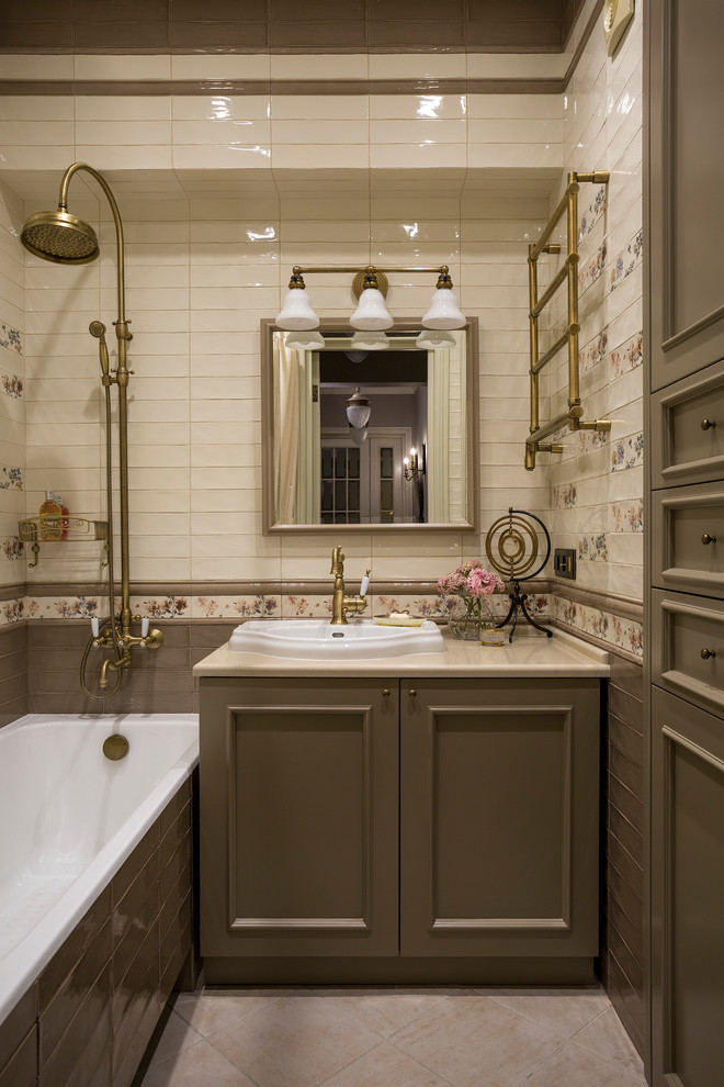 На фото: маленькая главная ванная комната в викторианском стиле с фасадами с утопленной филенкой, серыми фасадами, ванной в нише, душем над ванной, бежевой плиткой, серой плиткой и накладной раковиной для на участке и в саду