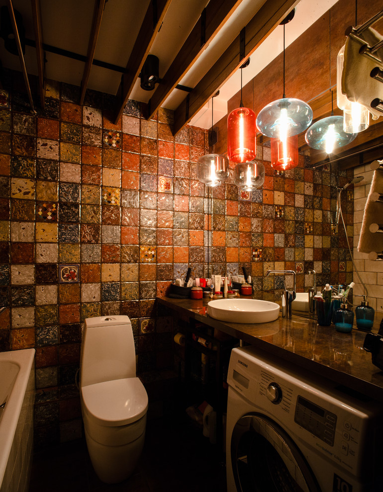 На фото: главная ванная комната среднего размера в стиле лофт с ванной в нише, душем над ванной, унитазом-моноблоком, разноцветной плиткой, керамической плиткой, разноцветными стенами, полом из керамической плитки, врезной раковиной и столешницей из искусственного камня с