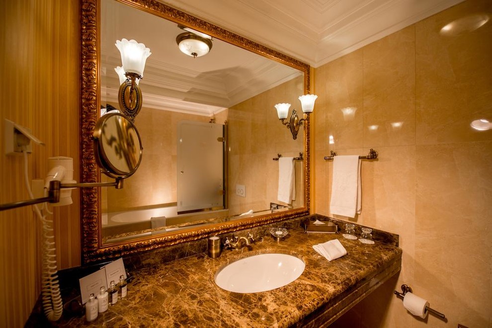 Foto di una stanza da bagno padronale tradizionale di medie dimensioni con piastrelle beige e top in marmo