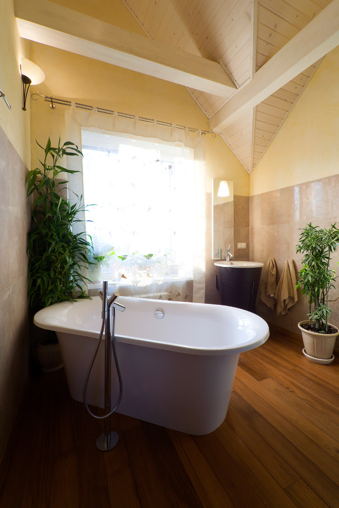 Exempel på ett mellanstort modernt en-suite badrum, med skåp i mörkt trä, ett fristående badkar, en öppen dusch, en toalettstol med hel cisternkåpa, brun kakel, porslinskakel, beige väggar, mörkt trägolv och ett piedestal handfat