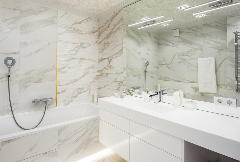 Идея дизайна: главная ванная комната в современном стиле с плоскими фасадами, белыми фасадами, ванной в нише, бежевой плиткой, монолитной раковиной и белой столешницей