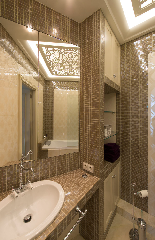 Small classic bathroom in Other with recessed-panel cabinets, beige cabinets, a submerged bath, a shower/bath combination, a one-piece toilet, beige tiles, ceramic tiles, beige walls, porcelain flooring, a submerged sink, tiled worktops, beige floors and a hinged door.
