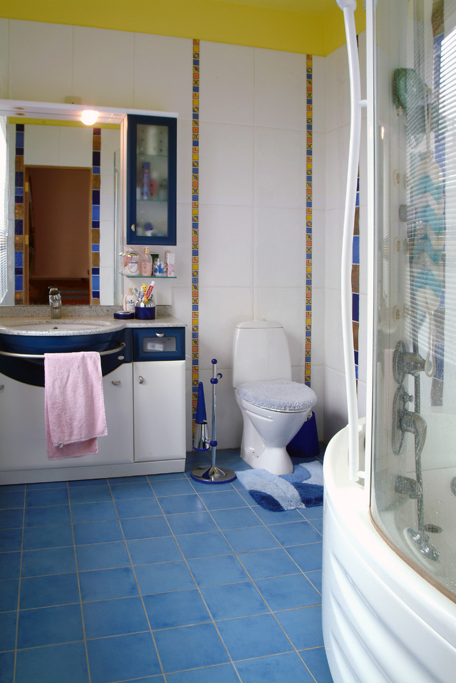 На фото: главная ванная комната среднего размера в современном стиле с плоскими фасадами, белыми фасадами, угловой ванной, душем над ванной, унитазом-моноблоком, белой плиткой, керамической плиткой, белыми стенами, полом из керамической плитки, врезной раковиной, столешницей из кварцита, синим полом и душем с раздвижными дверями