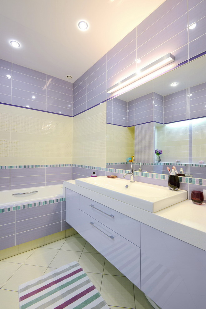 Idéer för mellanstora funkis en-suite badrum, med släta luckor, lila skåp, ett badkar i en alkov, en dusch/badkar-kombination, en vägghängd toalettstol, flerfärgad kakel, keramikplattor, flerfärgade väggar, klinkergolv i porslin, ett nedsänkt handfat, bänkskiva i akrylsten, vitt golv och med dusch som är öppen