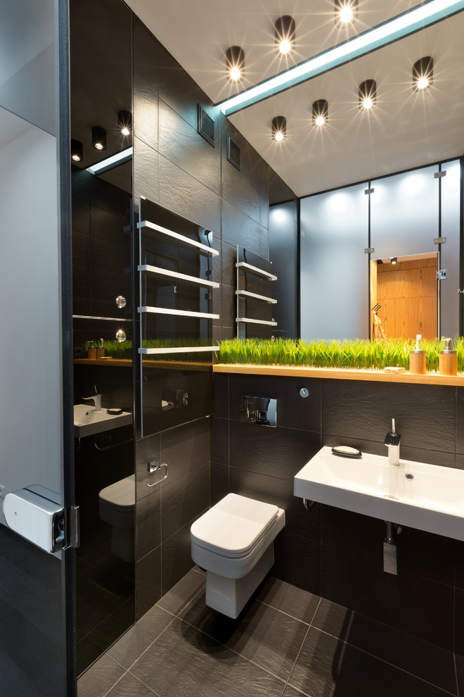 Photo of a small industrial bathroom in Other with a built-in shower, black tiles, black walls, ceramic flooring and solid surface worktops.