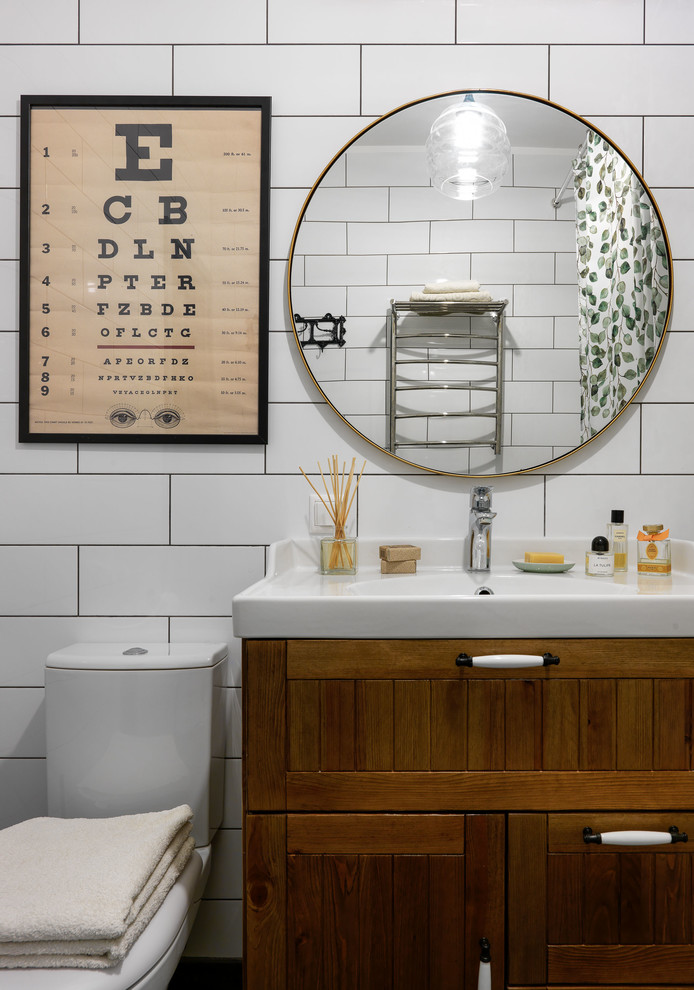 Modern inredning av ett badrum, med skåp i shakerstil, skåp i mellenmörkt trä, vit kakel, ett integrerad handfat och dusch med duschdraperi