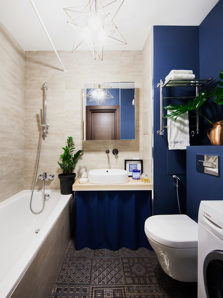 На фото: маленькая главная ванная комната в современном стиле с ванной в нише, душем над ванной, инсталляцией, бежевой плиткой, синими стенами, настольной раковиной, серым полом, шторкой для ванной и гигиеническим душем для на участке и в саду с