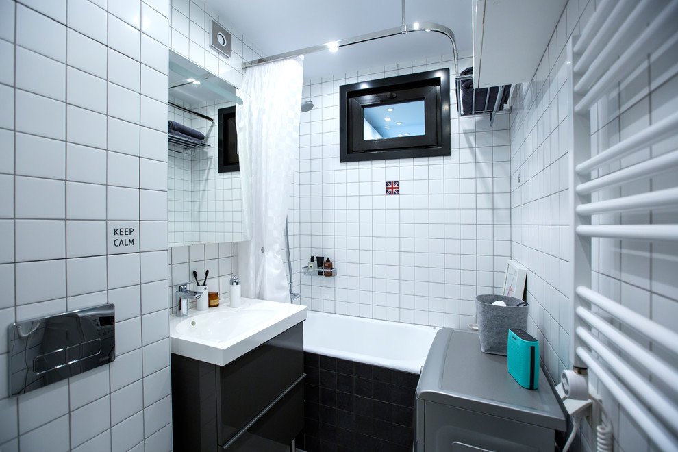 Inspiration pour une petite salle de bain principale design avec un placard à porte plane, des portes de placard noires, une baignoire en alcôve, un combiné douche/baignoire, un carrelage blanc, un lavabo intégré et une cabine de douche avec un rideau.
