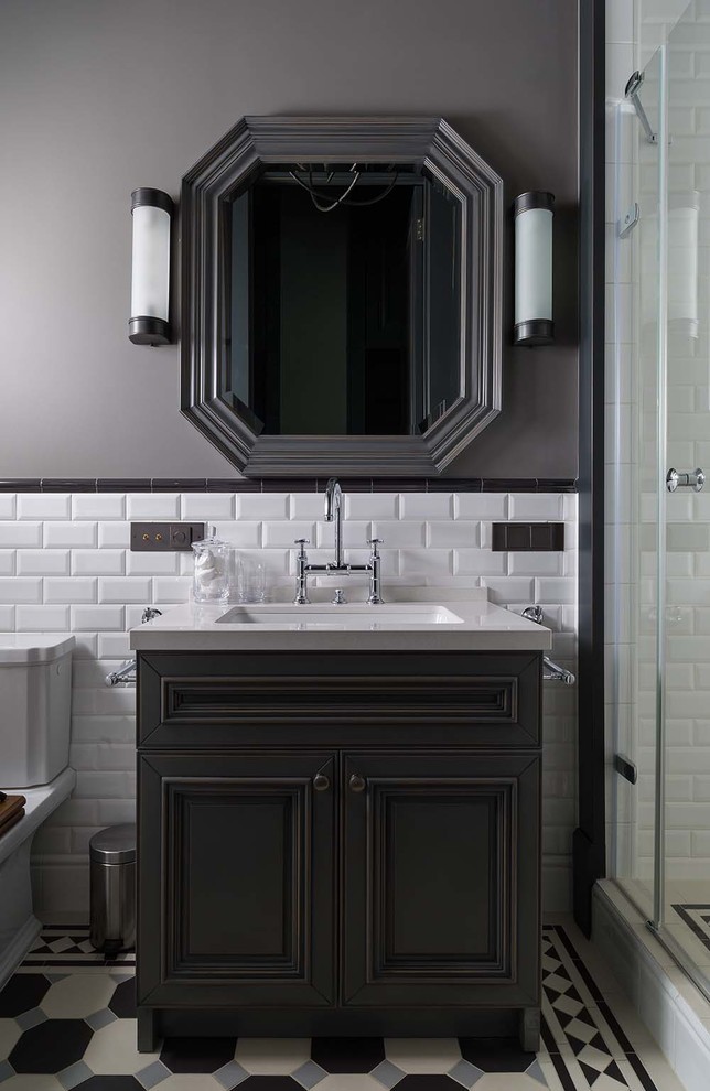 Klassisk inredning av ett badrum med dusch, med svarta skåp, vit kakel, tunnelbanekakel, grå väggar, ett undermonterad handfat och flerfärgat golv