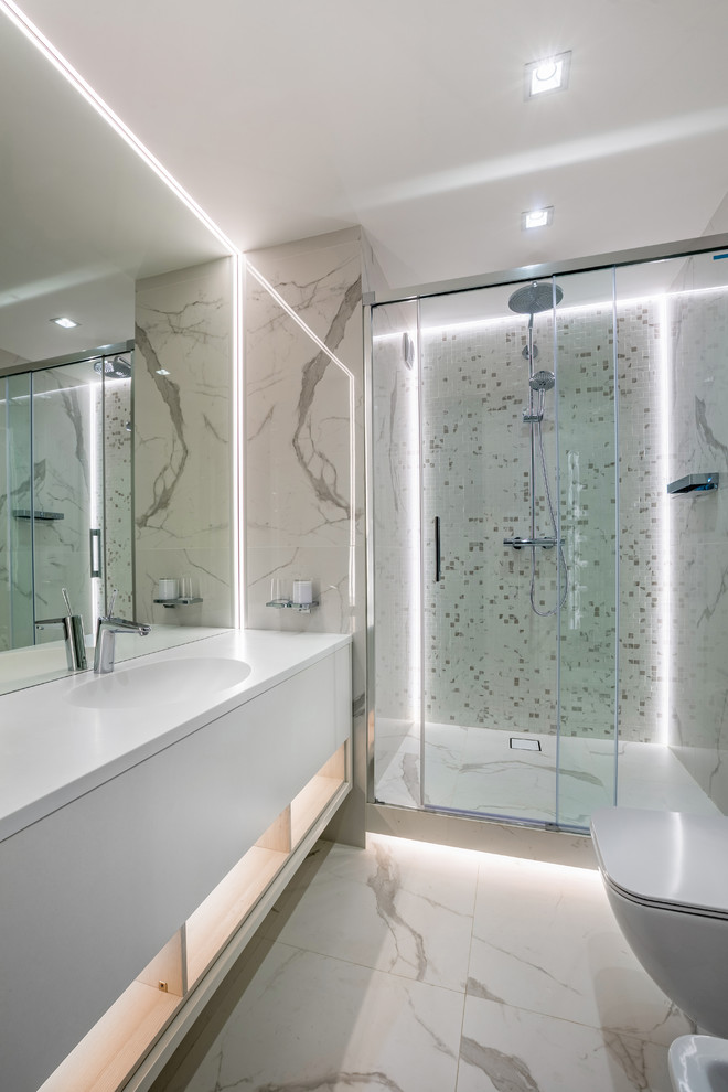 Modernes Duschbad mit flächenbündigen Schrankfronten, weißen Schränken, Duschnische, weißen Fliesen, integriertem Waschbecken, weißem Boden und weißer Waschtischplatte in Los Angeles