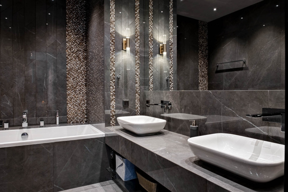 На фото: главная ванная комната в стиле неоклассика (современная классика) с серой плиткой, настольной раковиной, серым полом, ванной в нише и серой столешницей