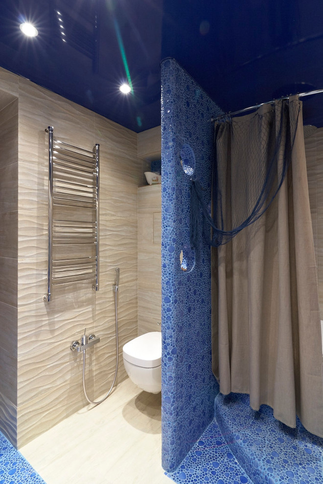 Idéer för ett stort maritimt en-suite badrum, med släta luckor, blå skåp, en jacuzzi, en dusch/badkar-kombination, en vägghängd toalettstol, blå kakel, kakel i småsten, beige väggar, klinkergolv i keramik, ett fristående handfat och kaklad bänkskiva