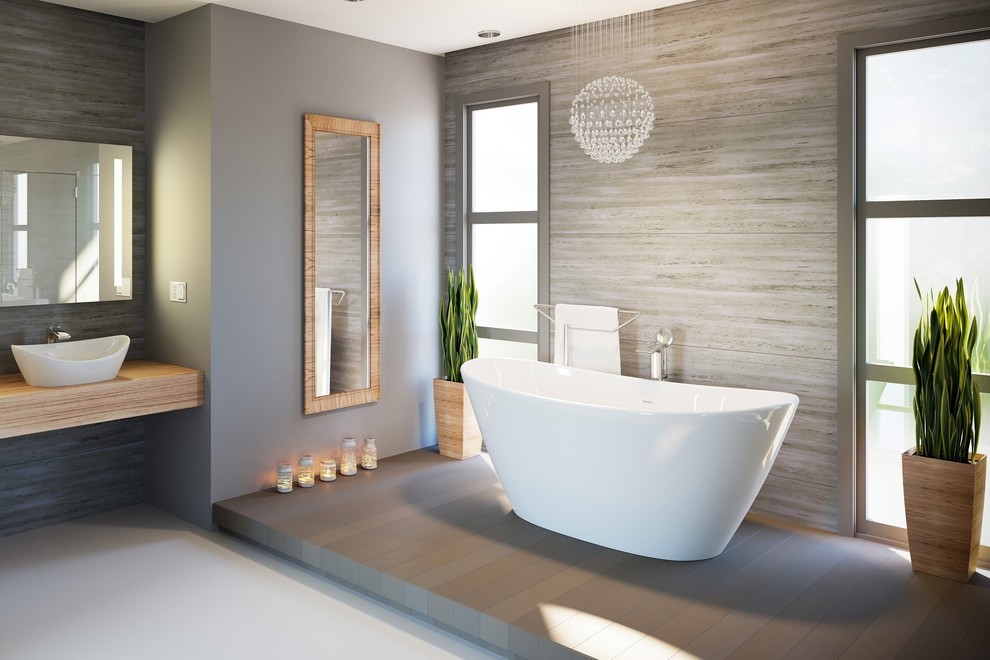 Imagen de cuarto de baño principal escandinavo de tamaño medio con bañera exenta, paredes grises, suelo de cemento y lavabo sobreencimera