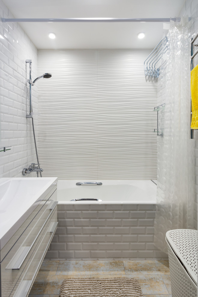 Bild på ett mellanstort funkis en-suite badrum, med släta luckor, vita skåp, ett badkar i en alkov, en dusch/badkar-kombination, vit kakel, keramikplattor, klinkergolv i porslin, dusch med duschdraperi och ett integrerad handfat