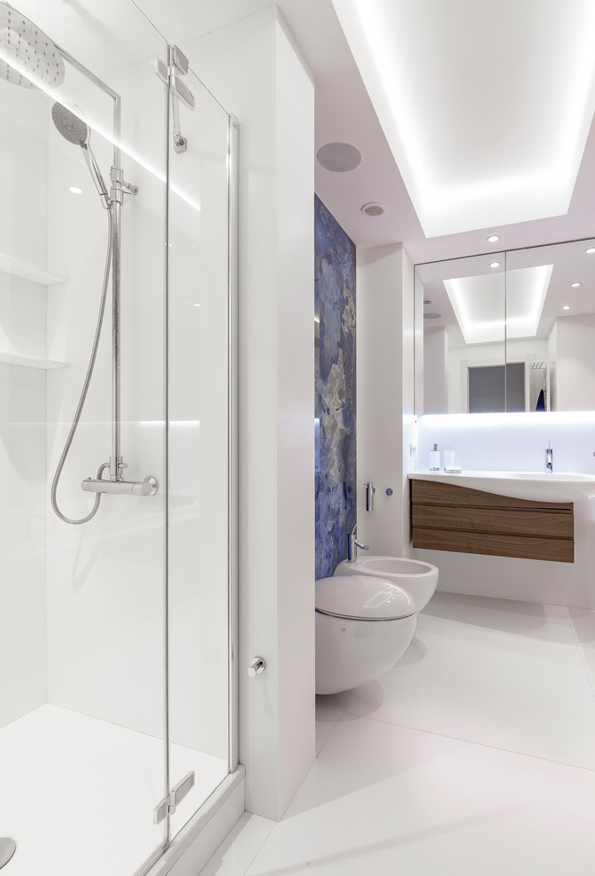 Ispirazione per una stanza da bagno con doccia minimal di medie dimensioni con doccia alcova, WC sospeso, piastrelle blu, pavimento in gres porcellanato, pavimento bianco, porta doccia a battente e lavabo integrato