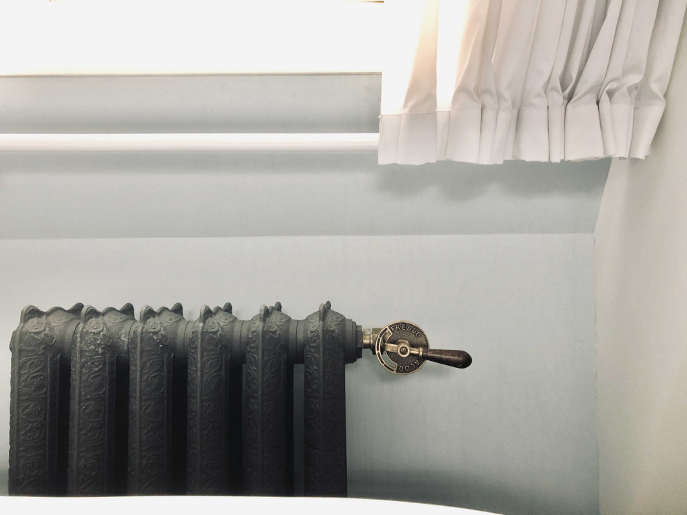 Idéer för att renovera ett stort vintage vit vitt badrum med dusch, med luckor med upphöjd panel, svarta skåp, ett fristående badkar, våtrum, en vägghängd toalettstol, vit kakel, keramikplattor, blå väggar, klinkergolv i porslin, ett undermonterad handfat, marmorbänkskiva, svart golv och dusch med gångjärnsdörr
