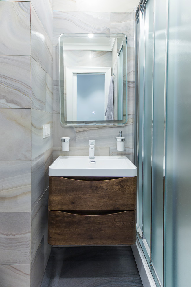 Kleines Modernes Badezimmer mit flächenbündigen Schrankfronten, grauen Fliesen, Porzellanfliesen, Porzellan-Bodenfliesen, grauem Boden, dunklen Holzschränken, Duschnische, Einbauwaschbecken und Schiebetür-Duschabtrennung in Moskau