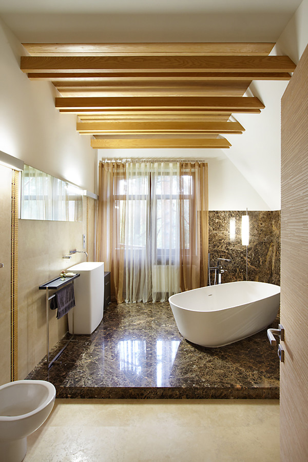 Идея дизайна: большая главная ванная комната в стиле фьюжн с отдельно стоящей ванной, бежевой плиткой, мраморным полом, плиткой из травертина, бежевыми стенами, монолитной раковиной и коричневым полом