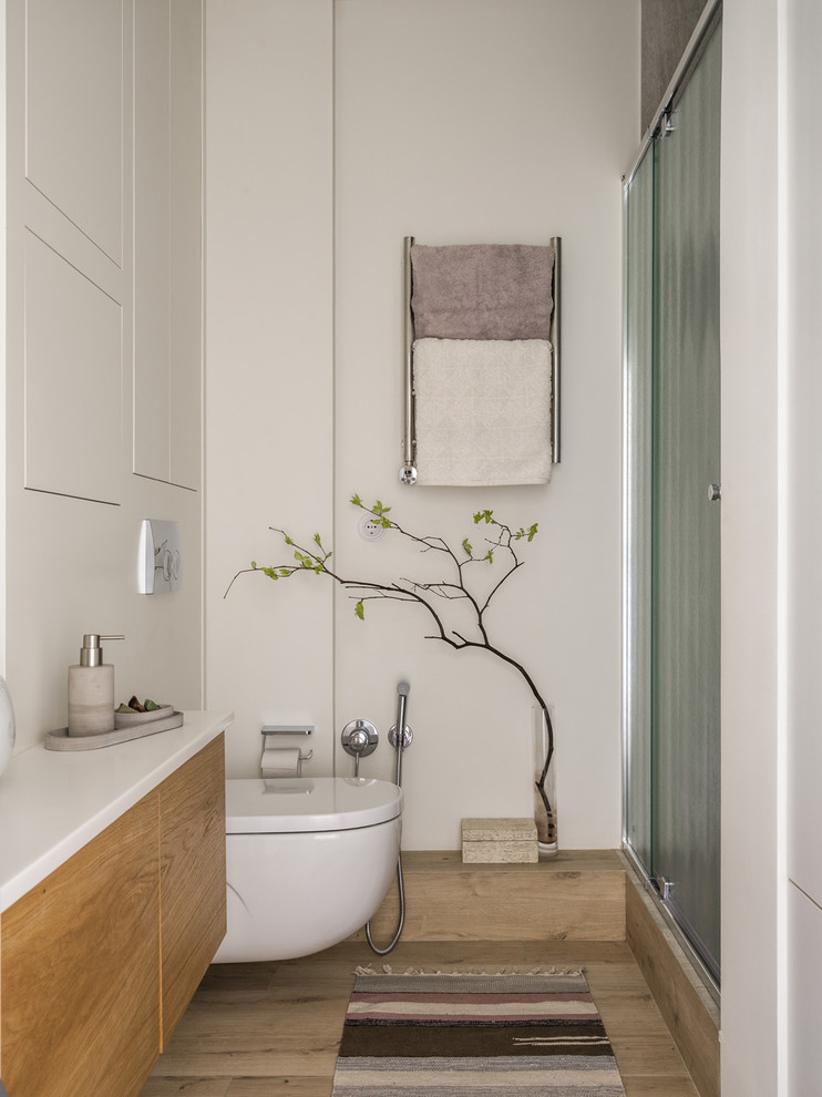 Aménagement d'une salle d'eau scandinave avec WC suspendus, un sol beige et une cabine de douche à porte coulissante.