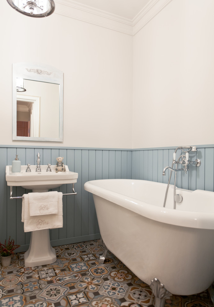 Стильный дизайн: детская ванная комната в классическом стиле с ванной на ножках, разноцветной плиткой, белыми стенами, раковиной с пьедесталом и разноцветным полом - последний тренд