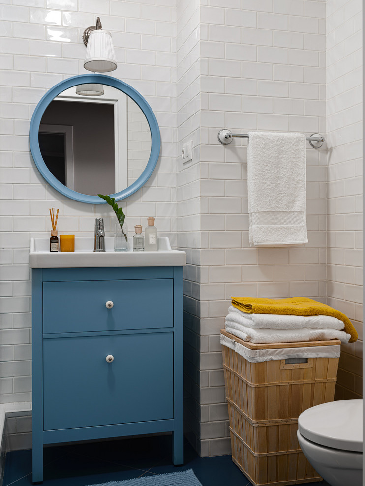 Свежая идея для дизайна: маленькая ванная комната в стиле неоклассика (современная классика) с плоскими фасадами, синими фасадами, белой плиткой, синим полом, плиткой кабанчик, белыми стенами, белой столешницей, тумбой под одну раковину, напольной тумбой и зеркалом с подсветкой для на участке и в саду - отличное фото интерьера