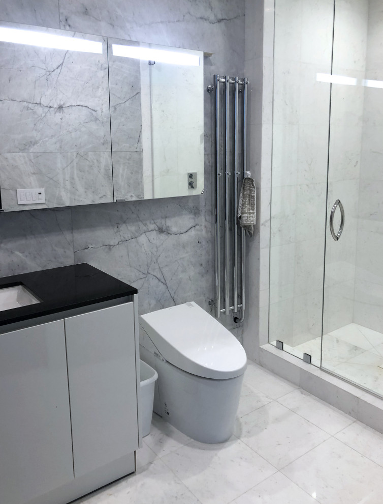 Exempel på ett mellanstort modernt svart svart badrum med dusch, med släta luckor, vita skåp, en dusch i en alkov, en toalettstol med separat cisternkåpa, brun kakel, marmorkakel, vita väggar, marmorgolv, ett undermonterad handfat, marmorbänkskiva, vitt golv och dusch med gångjärnsdörr