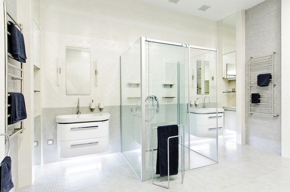 На фото: ванная комната в современном стиле с плоскими фасадами, белыми фасадами, отдельно стоящей ванной, душем без бортиков, серой плиткой и накладной раковиной