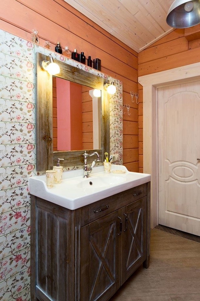 Foto på ett mellanstort lantligt en-suite badrum, med luckor med upphöjd panel, skåp i mellenmörkt trä, ett fristående badkar, en dusch/badkar-kombination, en toalettstol med hel cisternkåpa, flerfärgad kakel, keramikplattor, rosa väggar, klinkergolv i porslin, ett nedsänkt handfat och bänkskiva i akrylsten