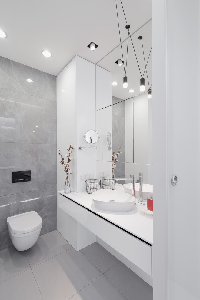 Источник вдохновения для домашнего уюта: главная ванная комната среднего размера в современном стиле с ванной в нише, инсталляцией, серой плиткой, керамогранитной плиткой, белыми стенами, полом из керамогранита, накладной раковиной и серым полом