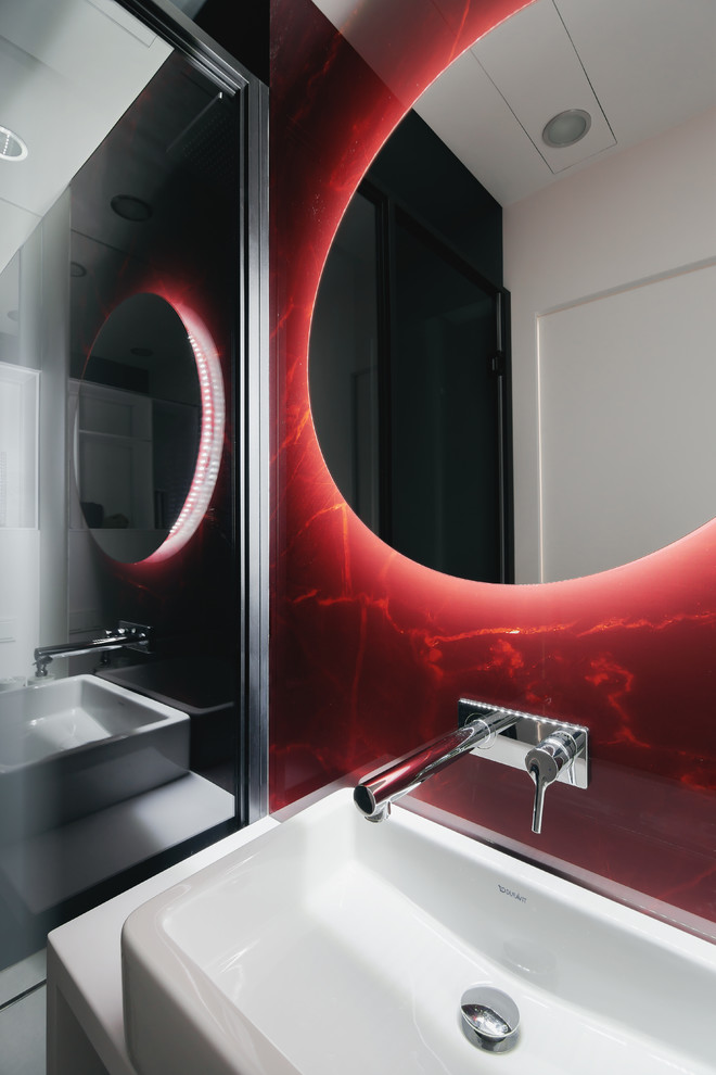 Immagine di una stanza da bagno con doccia design di medie dimensioni con WC sospeso, piastrelle grigie, piastrelle in gres porcellanato, pareti rosse, pavimento in gres porcellanato, lavabo da incasso e pavimento grigio