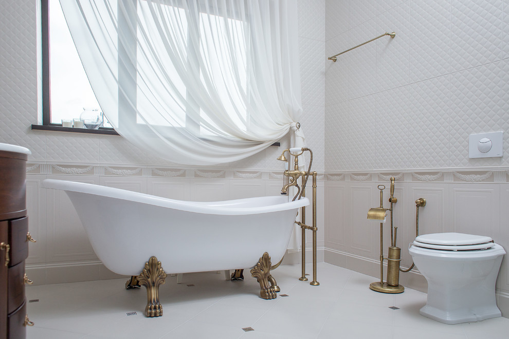 Exempel på ett klassiskt badrum, med ett badkar med tassar och en toalettstol med hel cisternkåpa
