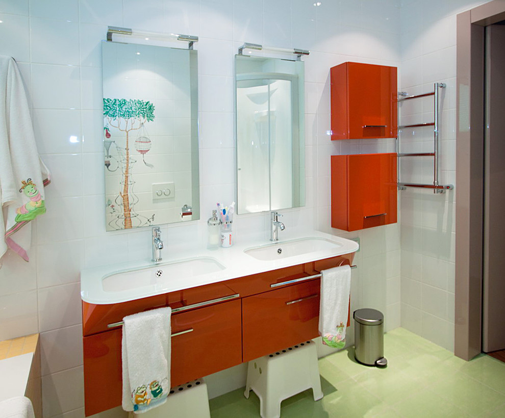 Foto på ett mellanstort eklektiskt vit badrum för barn, med släta luckor, röda skåp, ett platsbyggt badkar, en vägghängd toalettstol, flerfärgad kakel, keramikplattor, flerfärgade väggar, klinkergolv i keramik, ett avlångt handfat, bänkskiva i glas och grönt golv